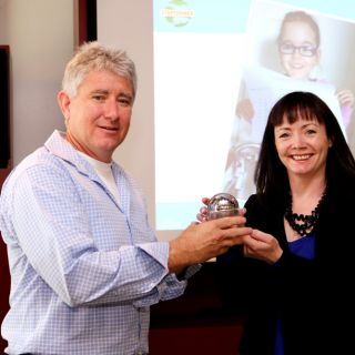 Warwick Bennett accepts an award on behalf of the University from the Cerebral Palsy Alliance’s Nathalie Maconachie.