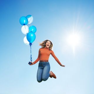 Girl jumping with balloons