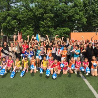 UC students outside with Tianshan No.1 Primary School students and teachers