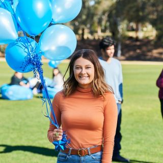 student with balloons