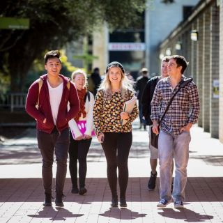 A group of UC students walk along the concourse