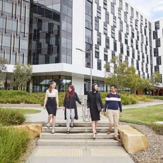 Four students walking on the university campus