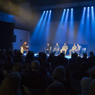 Program participants perform a play on stage in front of an audience